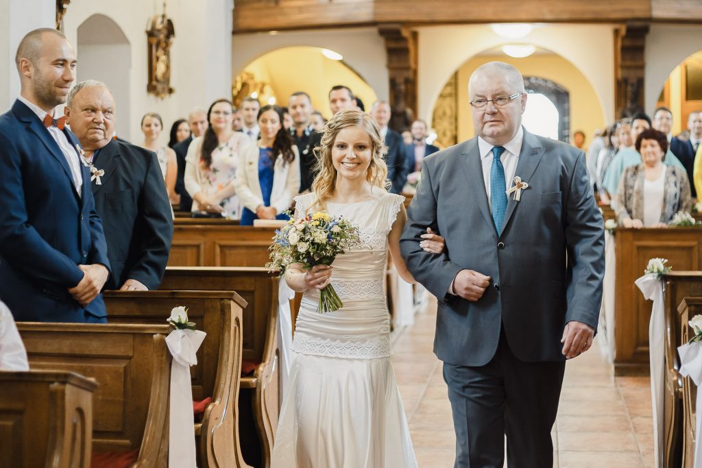 Nevesta v kostole kráča k oltáru s otcom