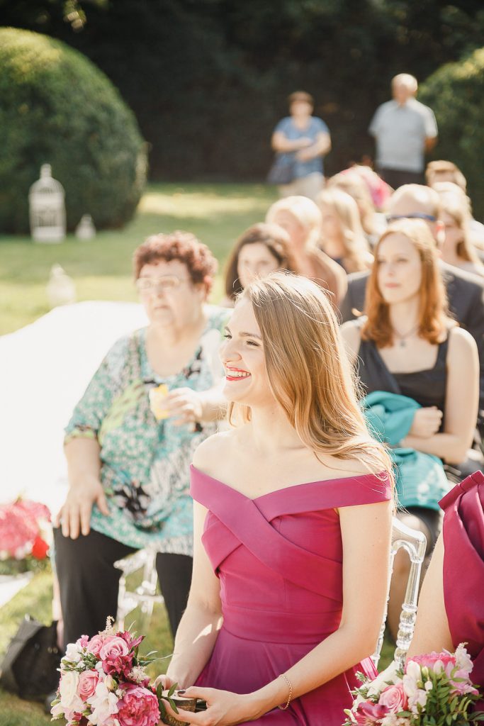 Družička vo fialových šatách na obrade vonku v zámku Halbturn