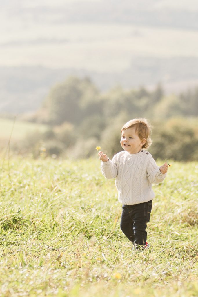 chlapec na fotení zbiera lúčne kvety